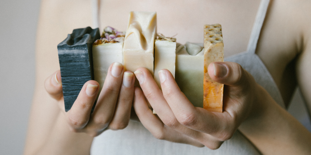 A lady holding a bunch of bars of soap