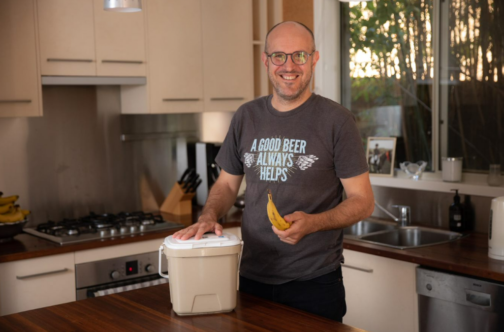 James Grugeon putting banana peel in compost caddy
