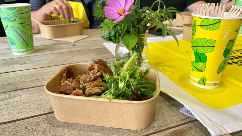 A meal made from reclaimed ingredients served in a compostable container, sitting on a table.