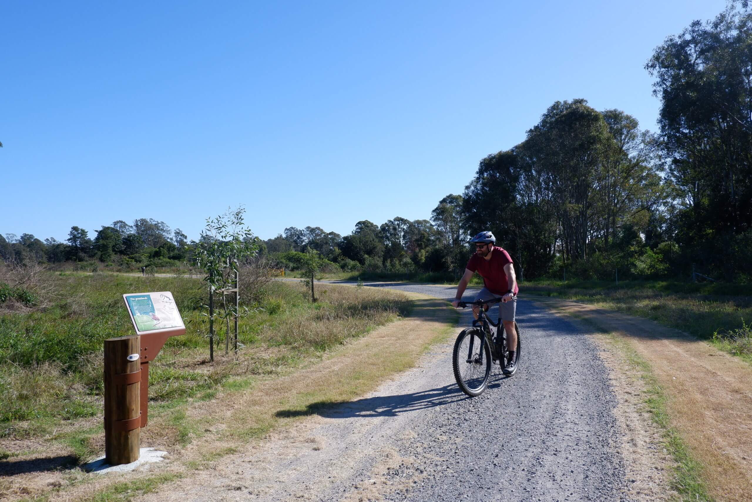 Man riding bike through wide gravel path